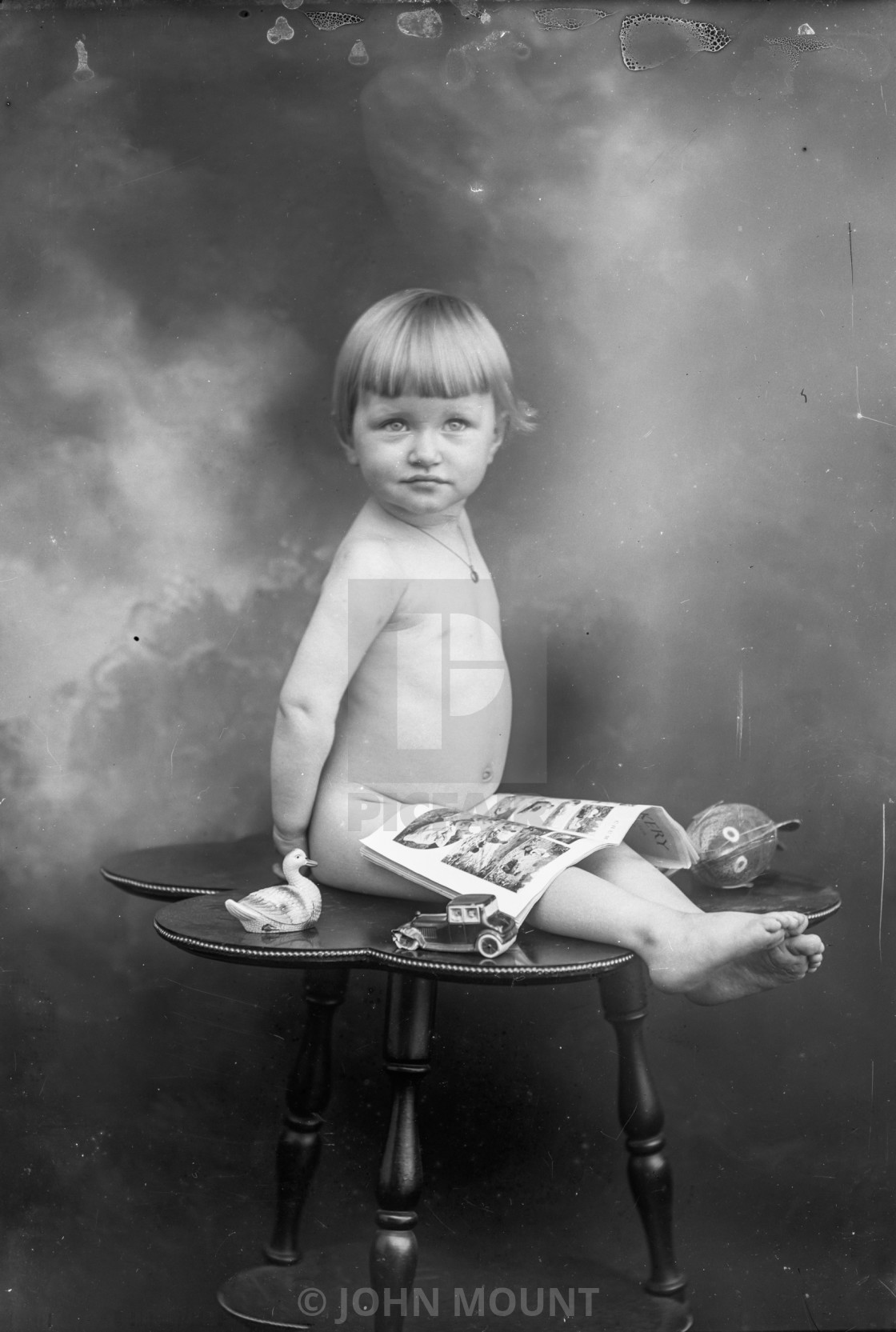 "VINTAGE PORTRAIT OF A BABY WITH TOYS AND NEWSPAPER COMICS" by JOHN MOUNT - £20.00 "VINTAGE PORTRAIT OF A BABY WITH TOYS AND NEWSPAPER COMICS" stock image