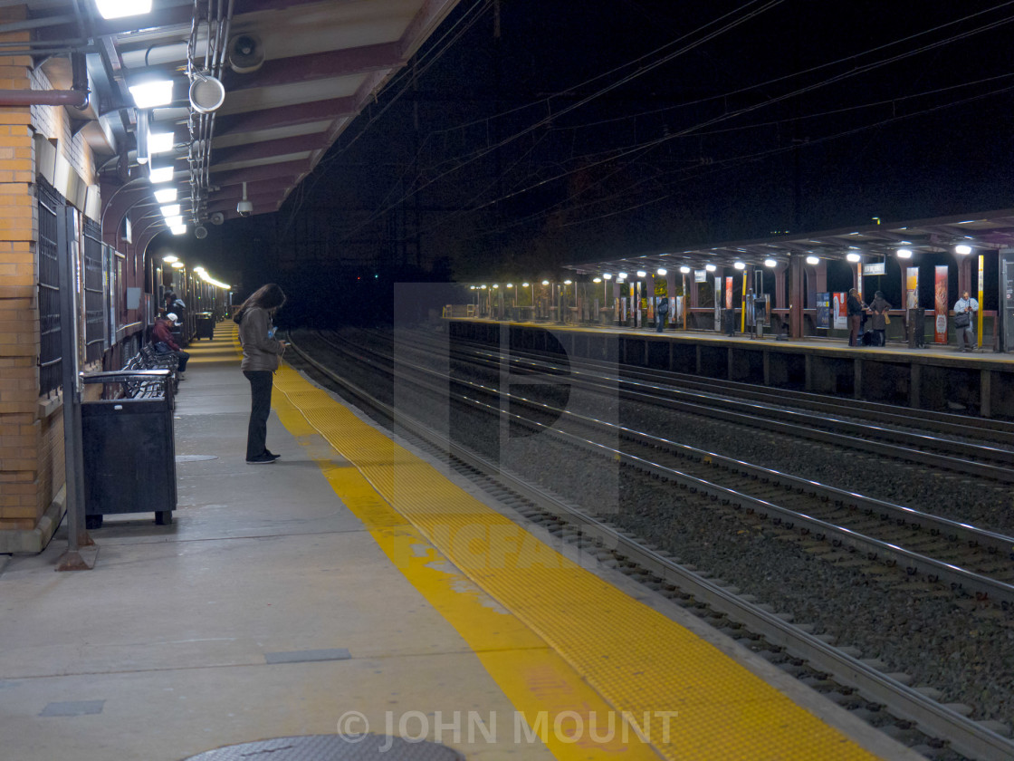 "WOMAN WAITING AT TRAIN STATION" by JOHN MOUNT - £20.00 "WOMAN WAITING AT TRAIN STATION" stock image