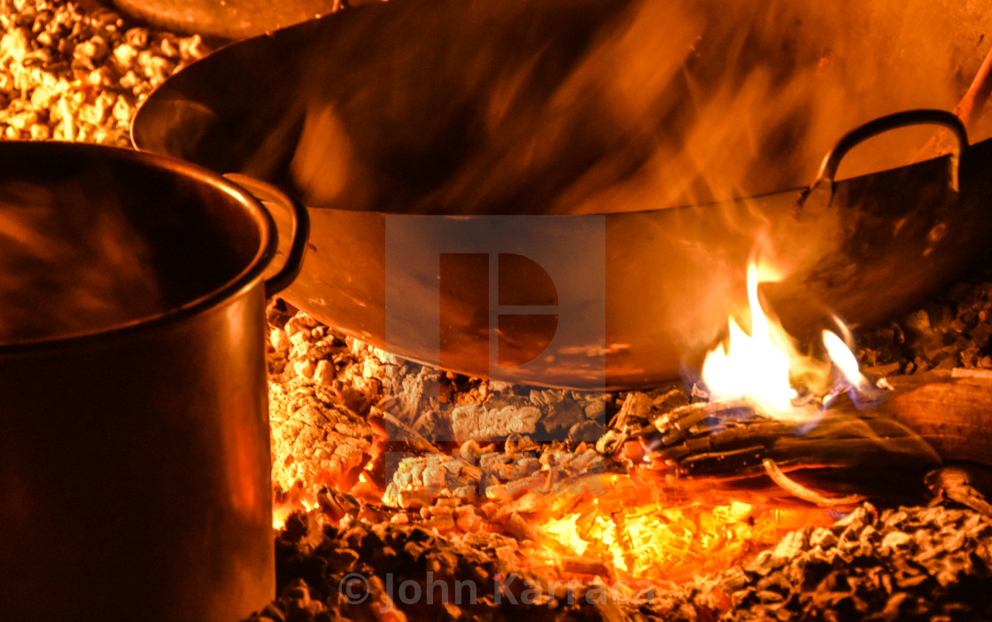 "the fire during the camping heats the pots and keeps them company" by John Karraca - $10.60 "the fire during the camping heats the pots and keeps them company" stock image