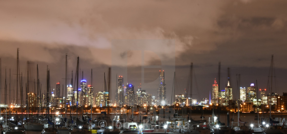 "a background panorama of the city of Melbourne seen from the pier with illuminated buildings above the boats moved by the waves of the sea" by John Karraca - $4.58 "a background panorama of the city of Melbourne seen from the pier with illuminated buildings above the boats moved by the waves of the sea" stock image