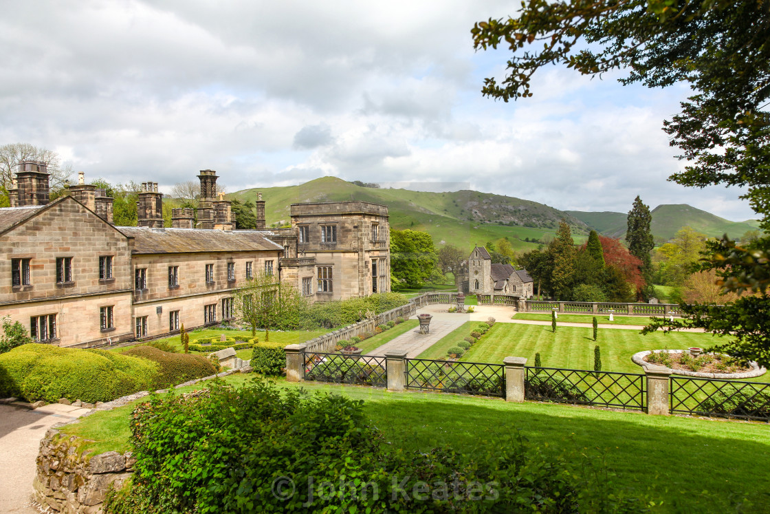 "Ilam Hall and gardens with Church Of The Holy Cross in the backg" stock image