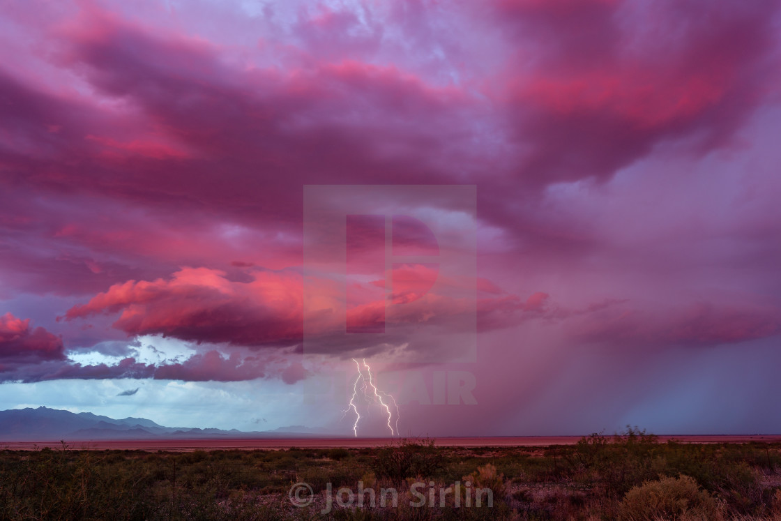 "Lightning strikes from a distant storm at sunset" stock image