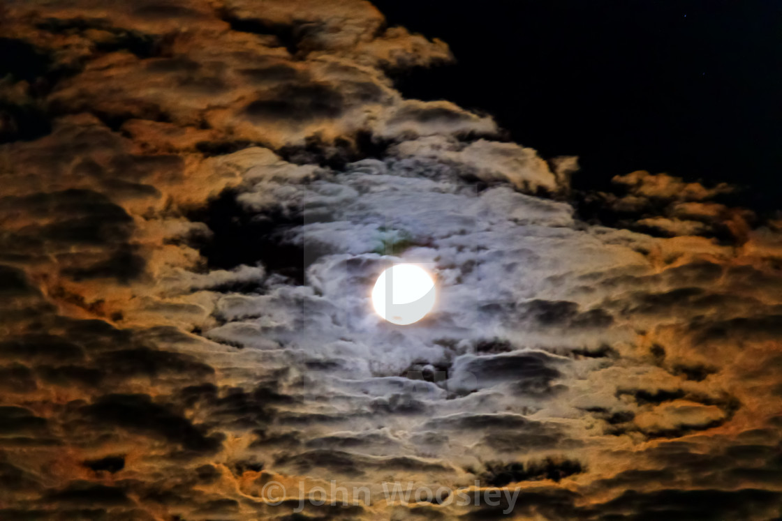 "Full moon behind clouds" stock image