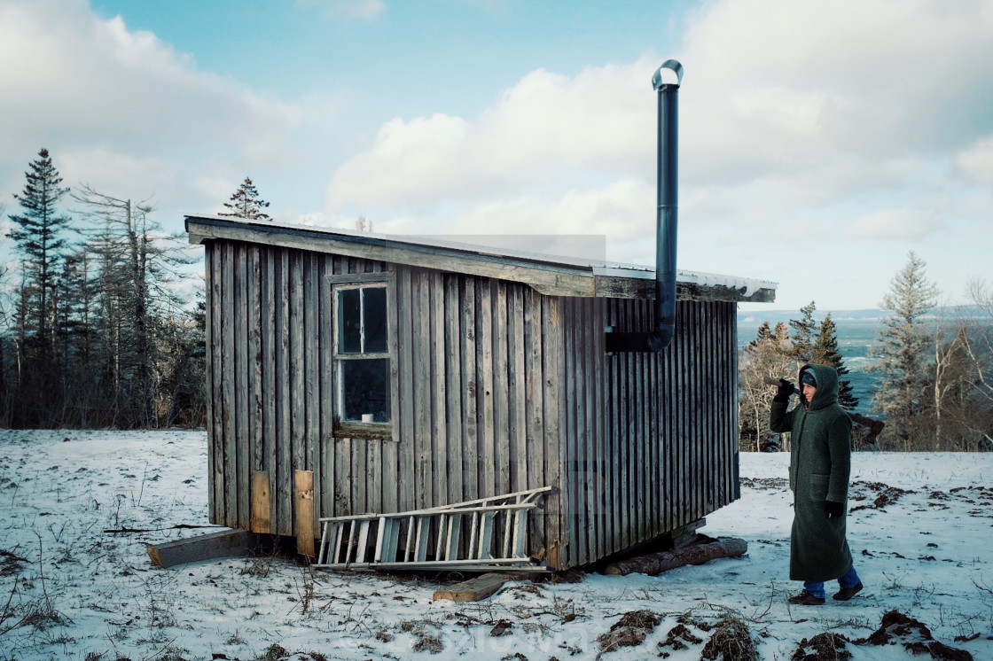 Young Girl With Ax Next To Her Cabin Close To The Sea Shore During