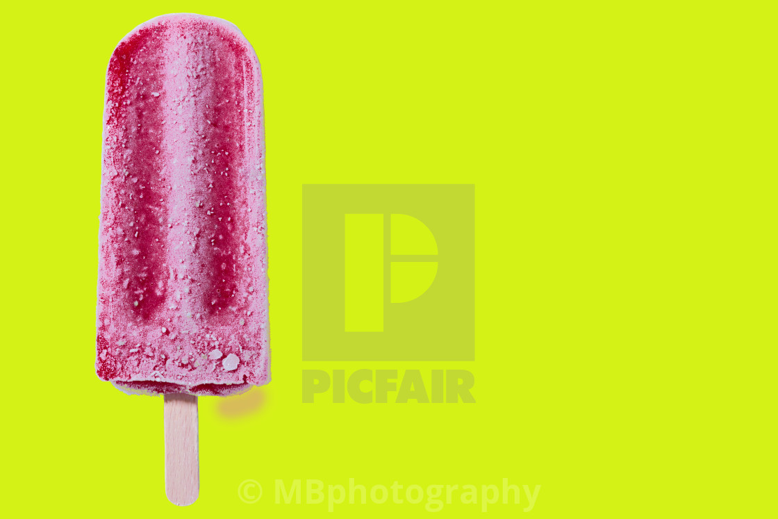 "Red popsicle on yellow background with copy space" stock image