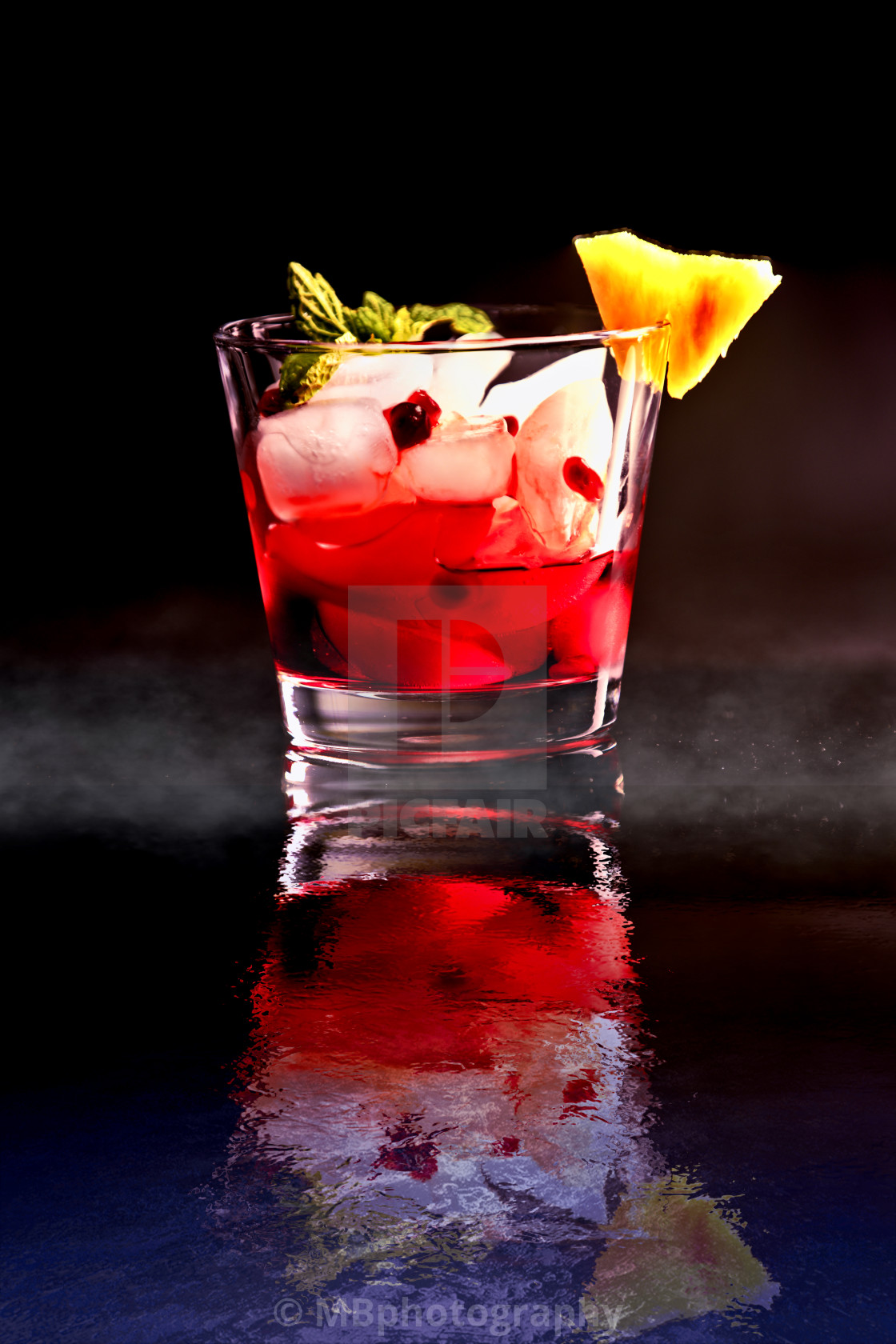 "Red Cocktail on ice with pomegranate seeds and pineapple" stock image