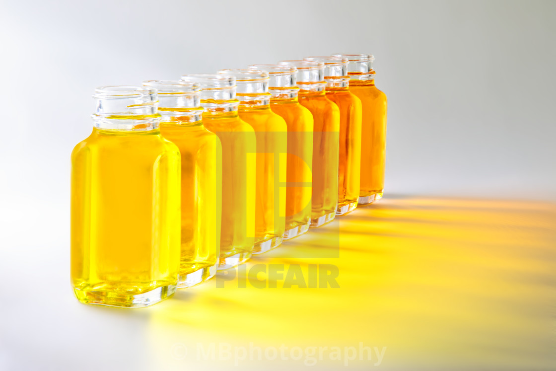 "Bottles with yellow fluids with different shades of yellow" stock image