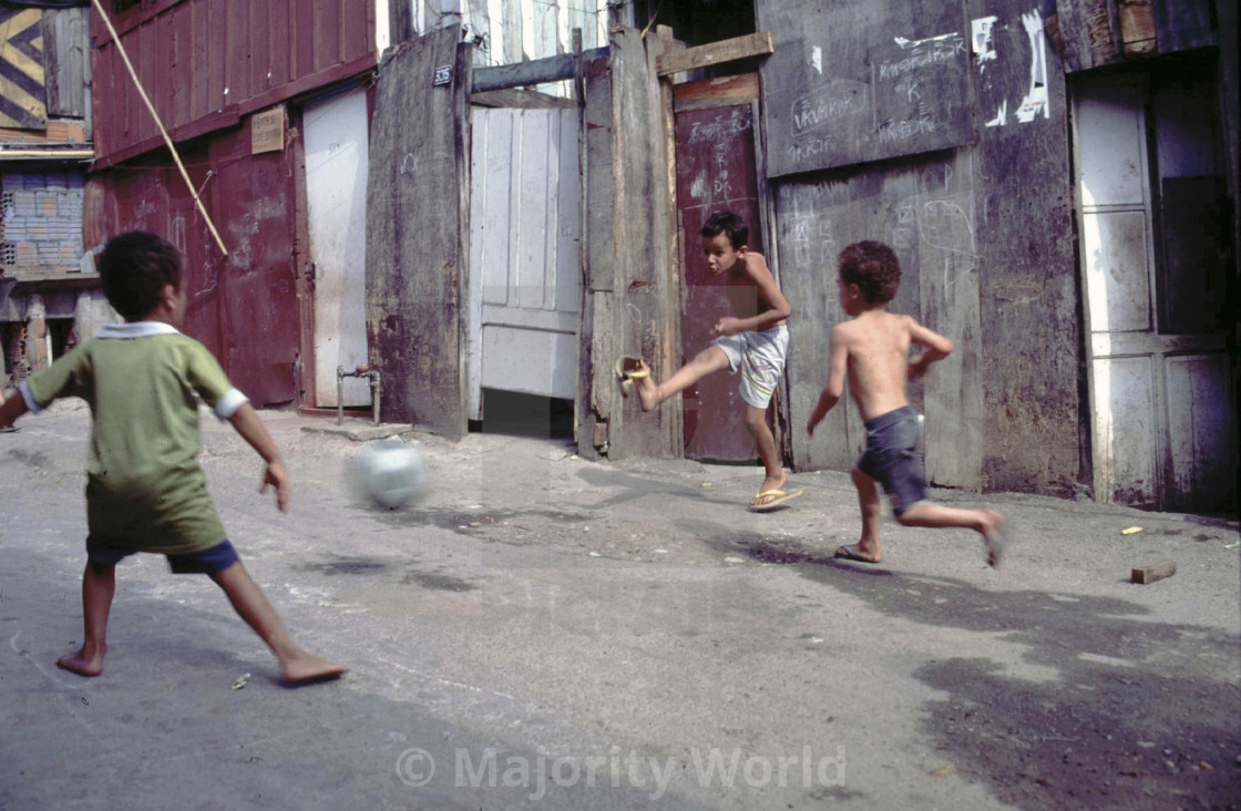 "CHILDREN PLAYING FOOTBALL IN THE SHANTY TOWNS OF SANTOS, BRAZIL. Photo ¬©..." stock image