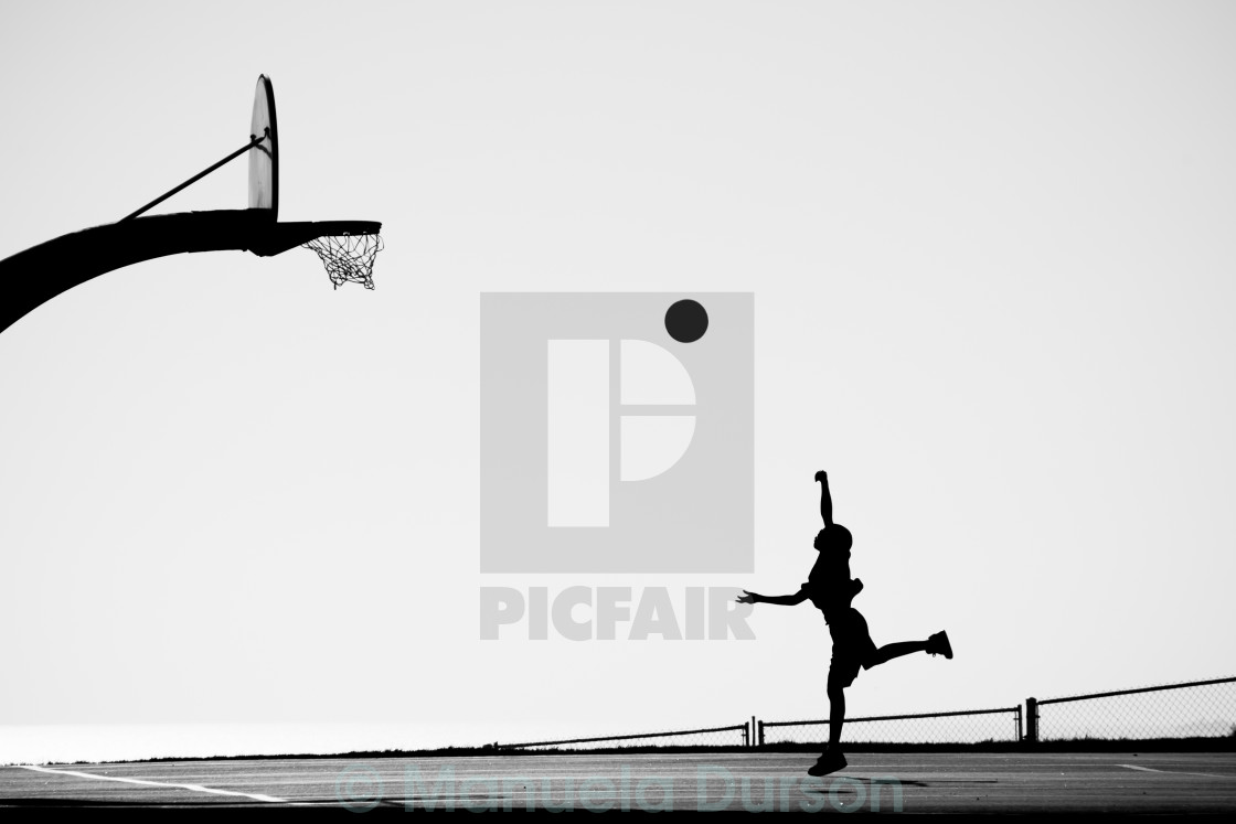 "Silhouette of Boy playing Basketball" stock image