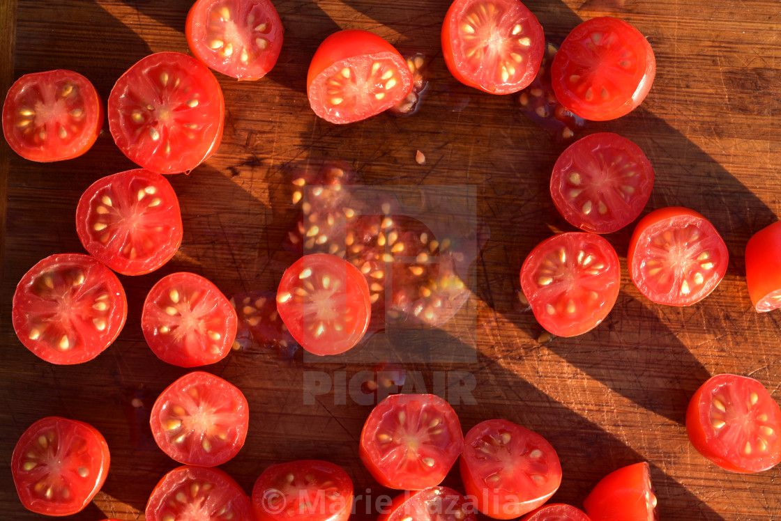 "above view of grape tomatoes cut into halves on wood cutting board" by Marie Kazalia - $15.16 "above view of grape tomatoes cut into halves on wood cutting board" stock image