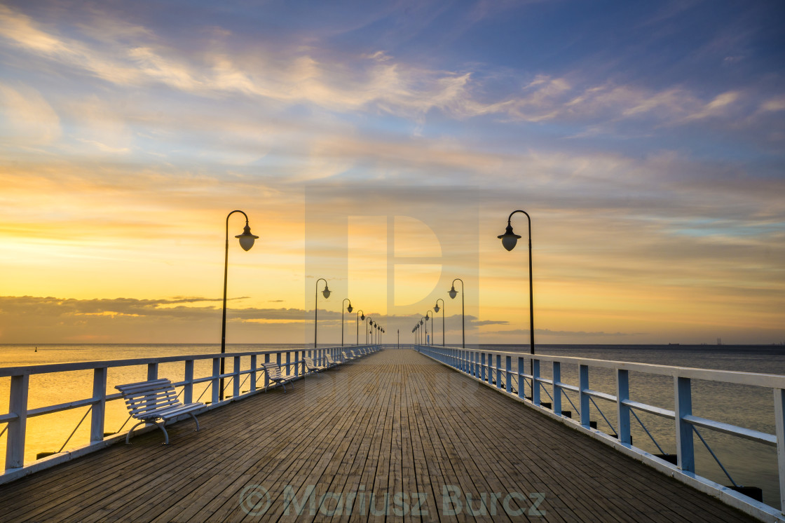 "wooden pier by the sea lit by stylish lamps at night" stock image