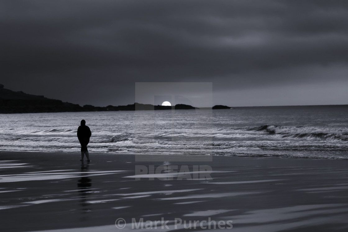 "Silhouette of Man Walking Alone on Beach During Sunset" stock image