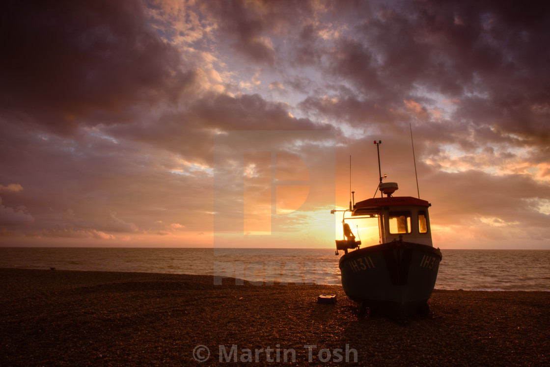 "Fishing boat on shingle beach" stock image