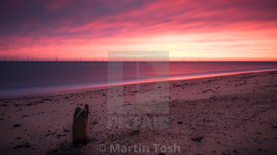 "Fiery sunrise over beach" stock image