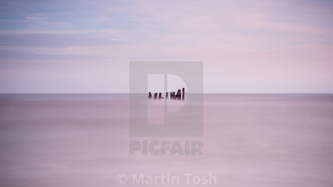 "Long exposure over old sea defences" stock image