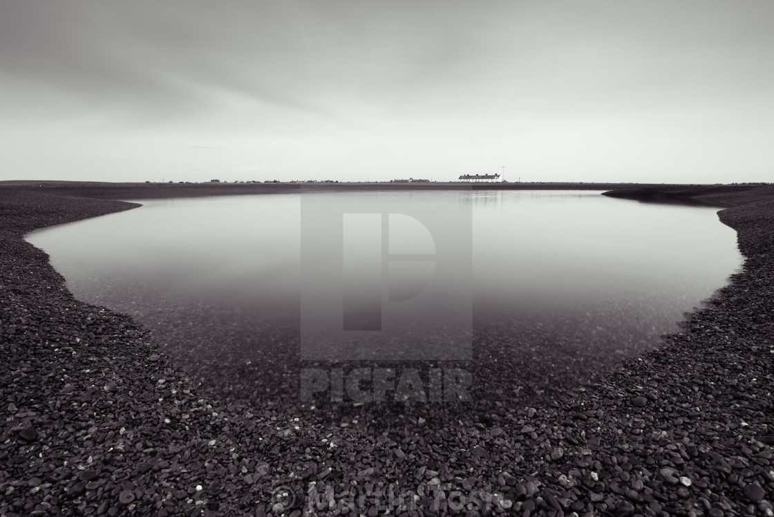 "Spill. Shingle lagoon mono with remote cottage" stock image