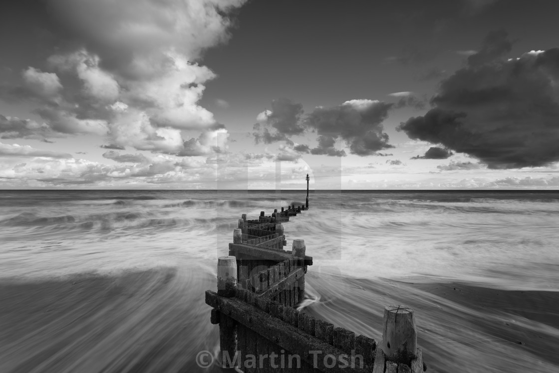 "Overstrand old groyne and receding waves. Mono" stock image