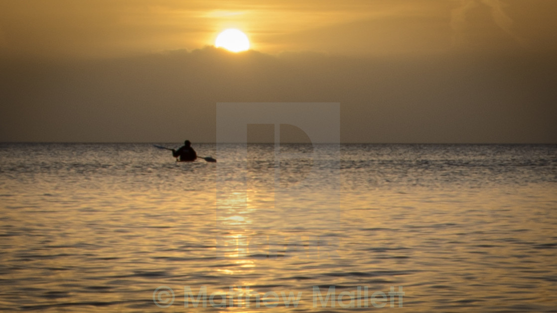 "Lone Kayaker Watching The Sunrise" stock image