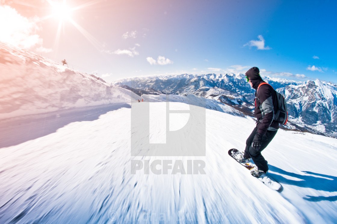 "snowboarder riding fast, motion blur, fisheye shot" stock image