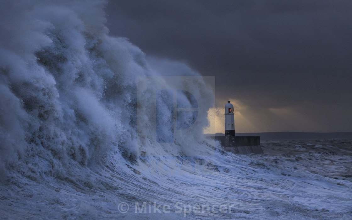 "Storm wave and Porthcawl lighthouse at sunrise" stock image