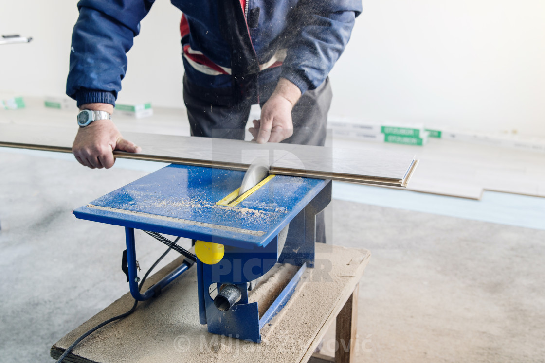 Professional Worker Using Circular Saw Cutting Of New Laminate