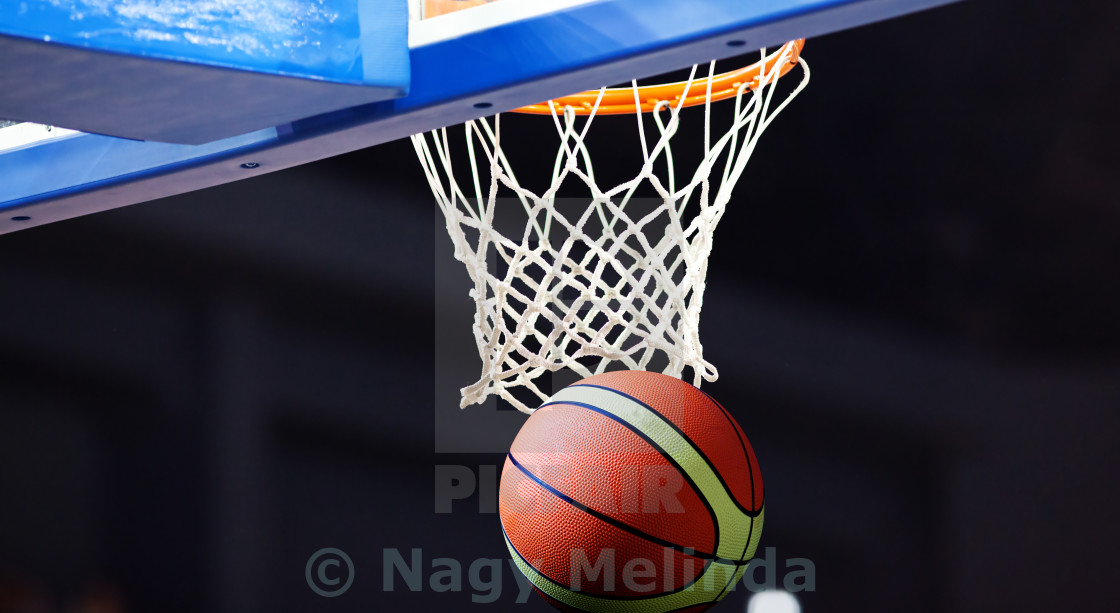 Basketball Going Through The Hoop At A Sports Arena License