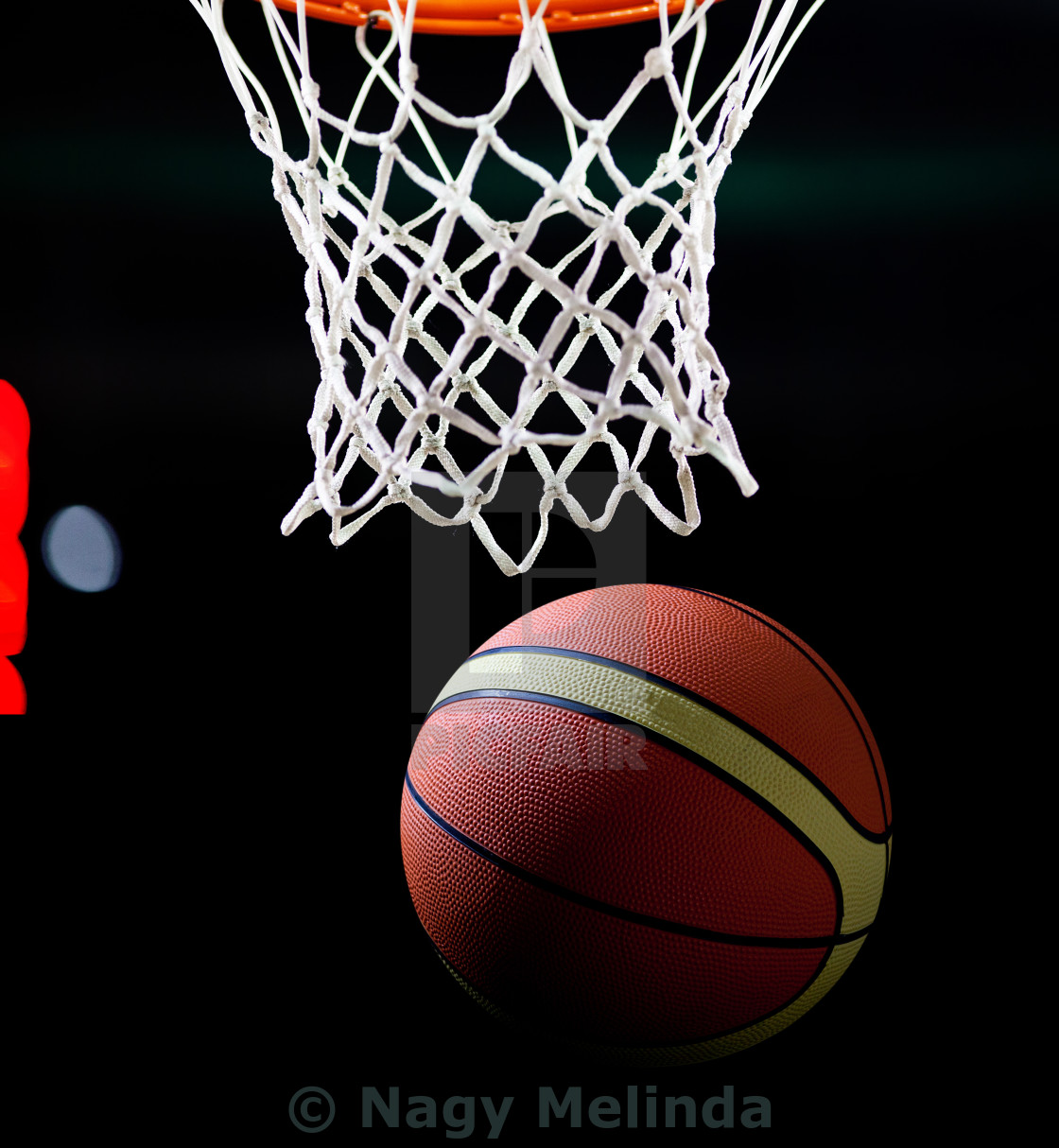 Basketball Going Through The Hoop At A Sports Arena License