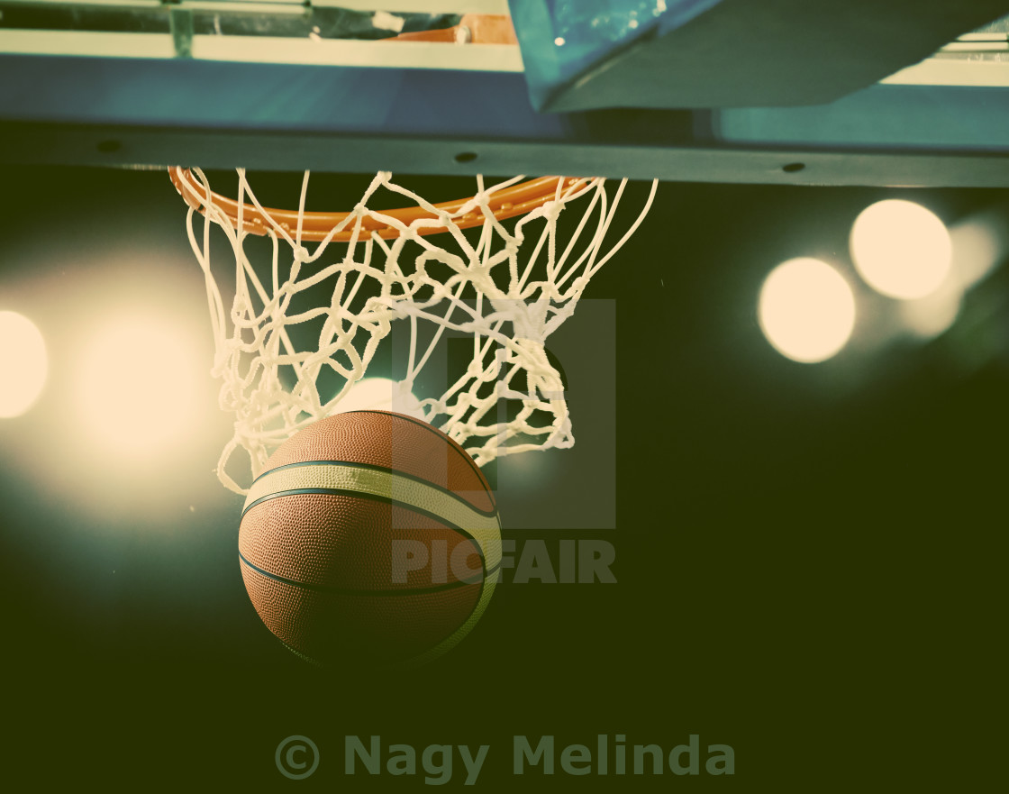 Basketball Going Through The Hoop At A Sports Arena License