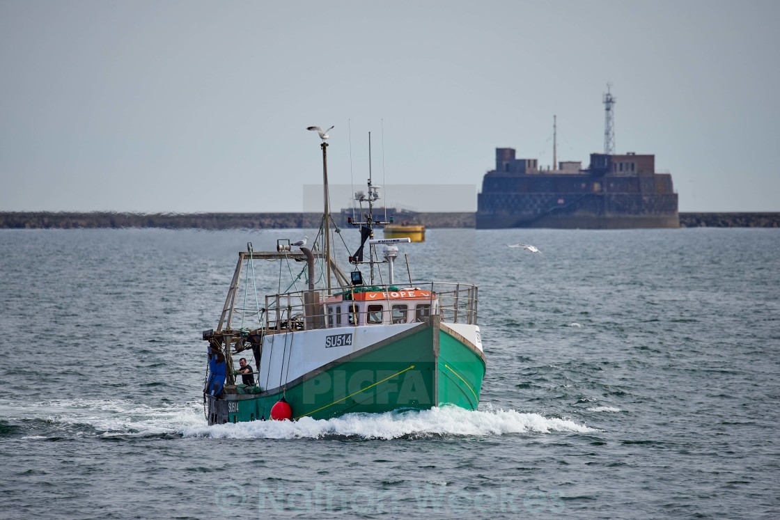 "Fishing vessel returns to port." stock image