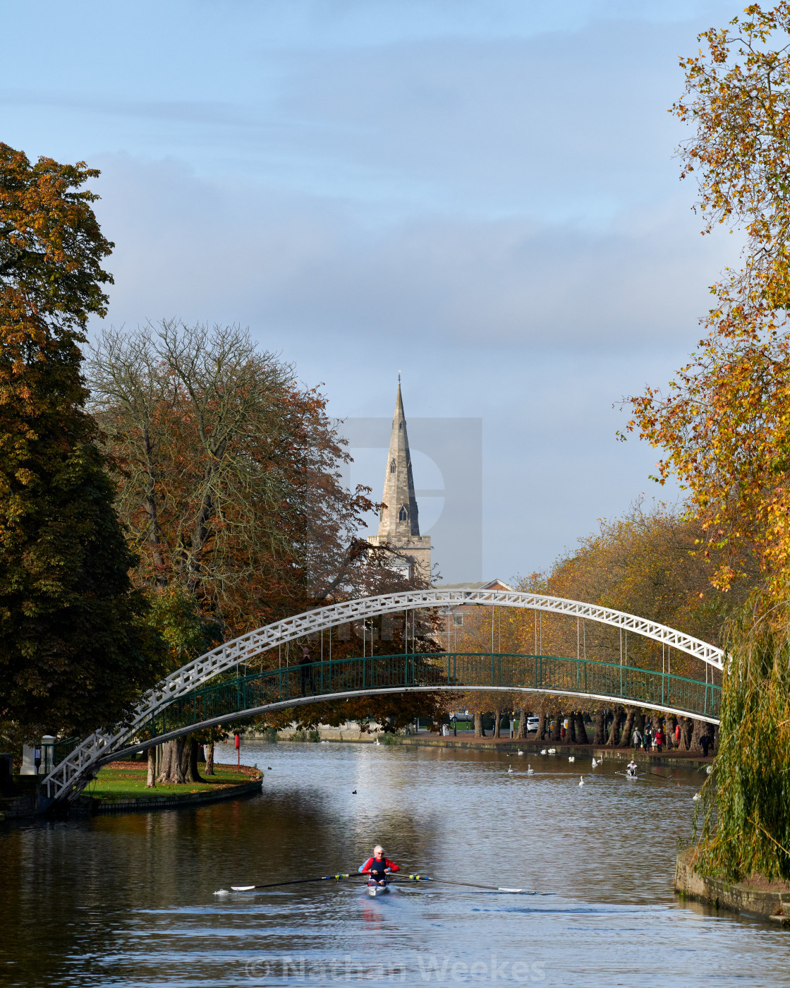 "A rower passes under Bedford Suspension Bridge on an autumn morn" stock image