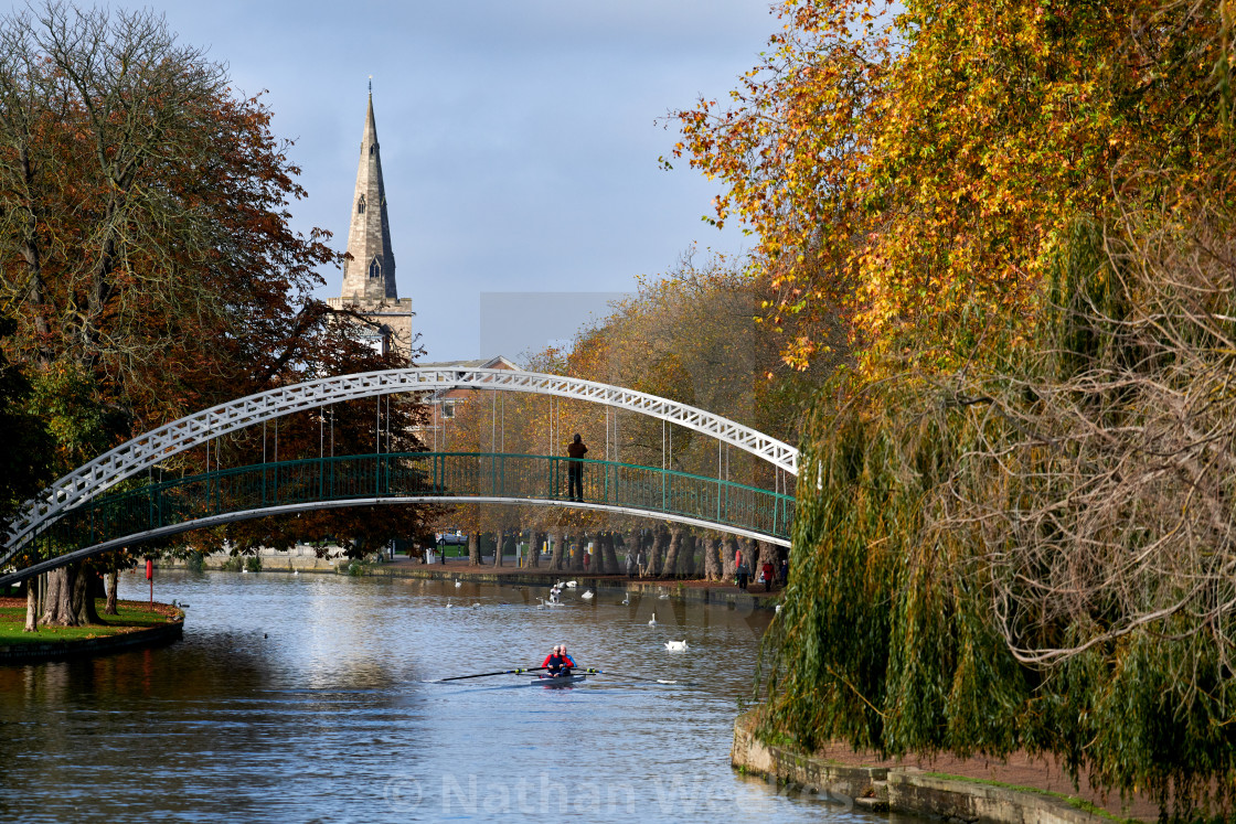 "A rower passes under Bedford Suspension Bridge on an autumn morn" stock image