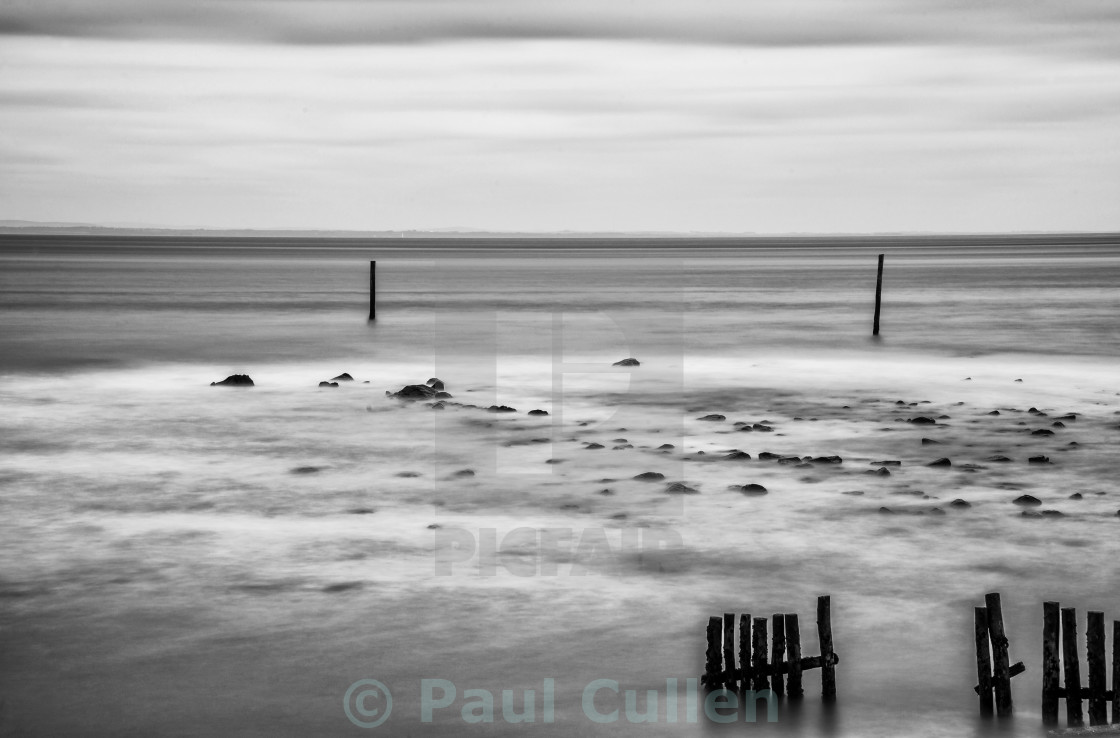 "Wooden posts in the sea. Monochrome." stock image