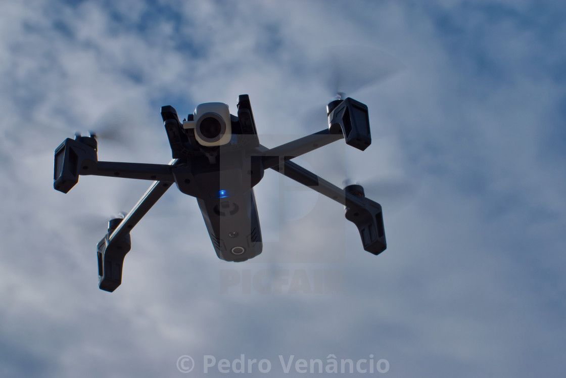 "Parrot Anafi flying against cloudy blue sky" stock image