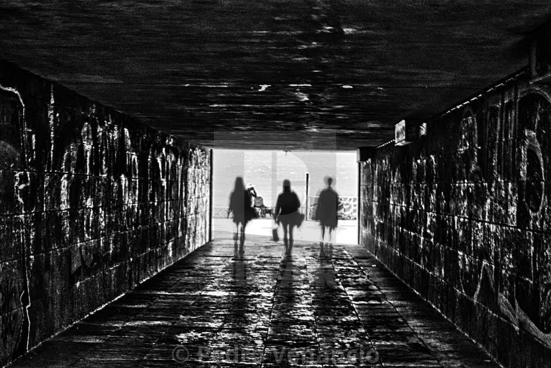 "People walking on the tunnel shadows and silhouettes" stock image