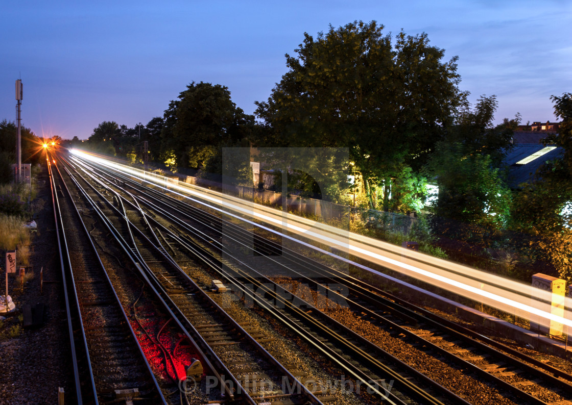 "A trace of light is left by a passing commuter train at dusk in south London, UK." by Philip Mowbray - $12.31 "A trace of light is left by a passing commuter train at dusk in south London, UK." stock image