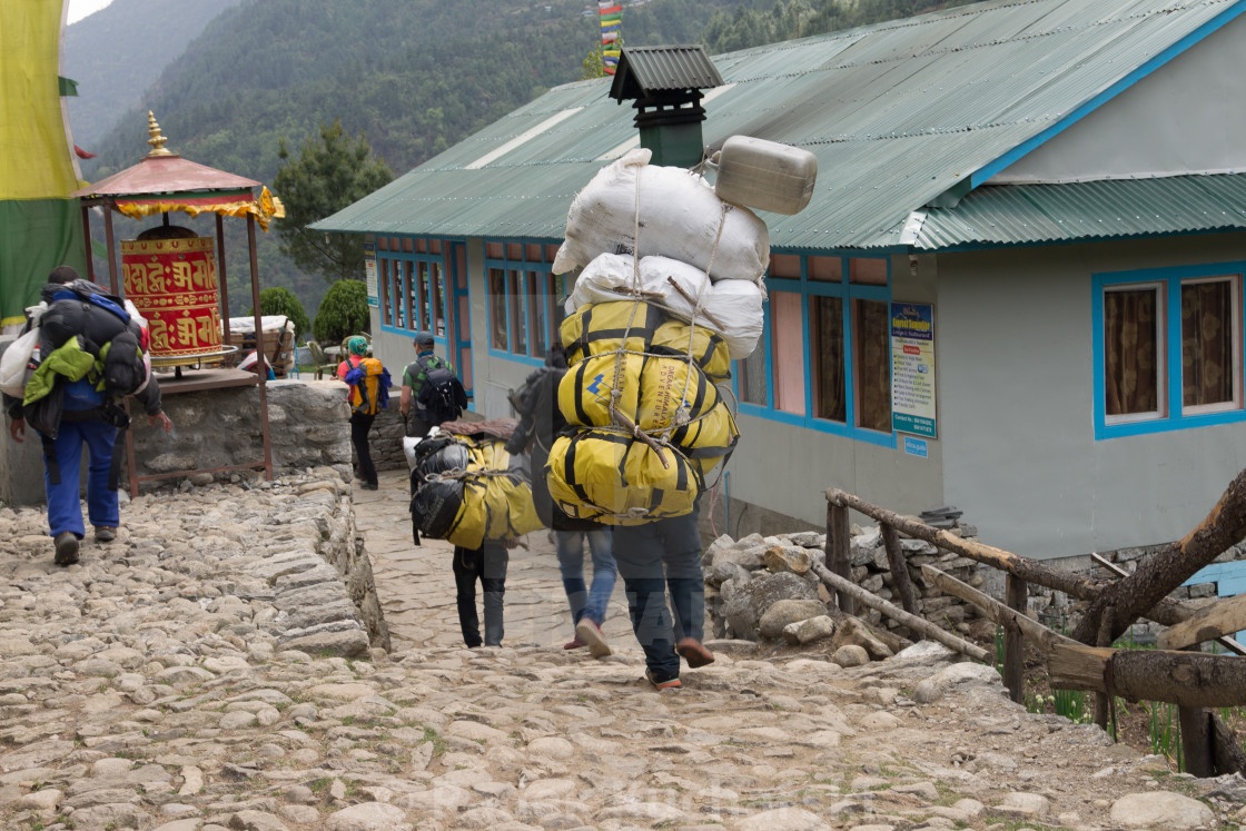 "Porter carrying a heavy loads on the Everest Base Camp trekking route" stock image