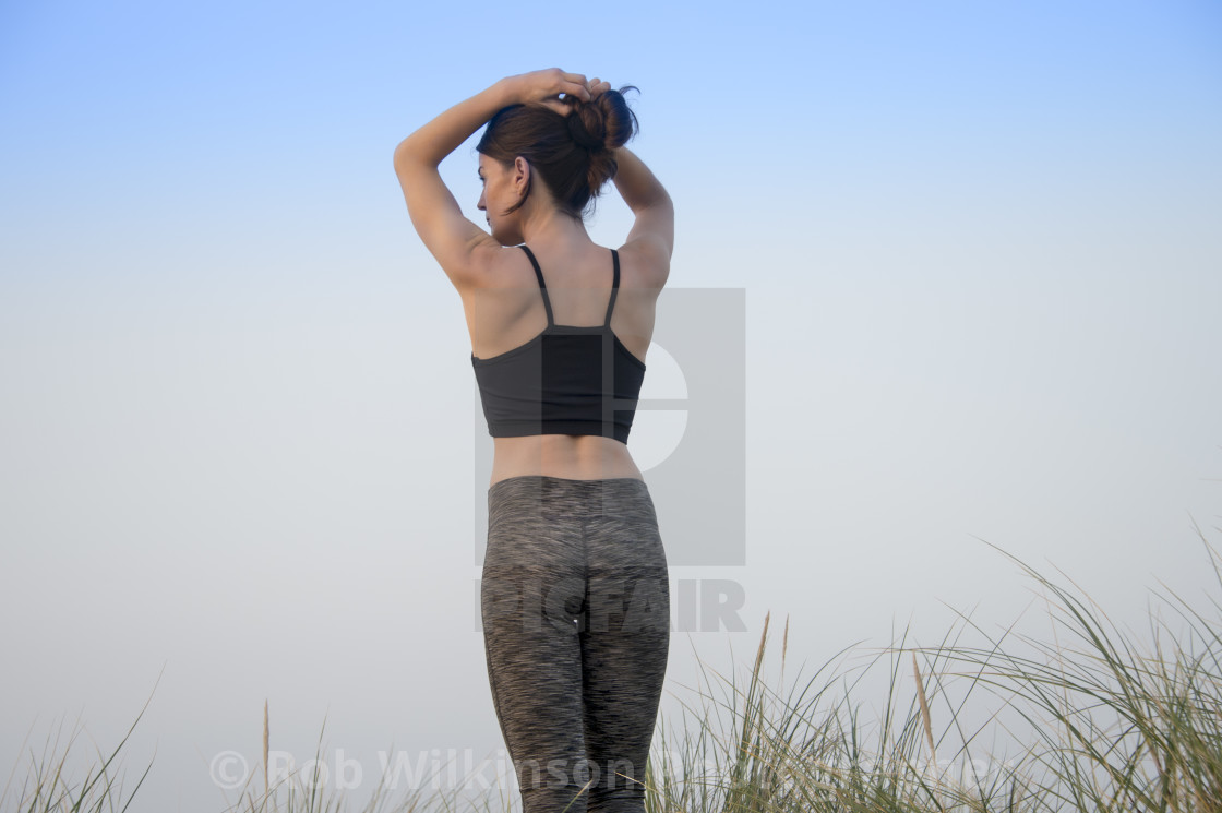 Back View Of A Sporty Woman Tying Her Hair Up Before Exercising