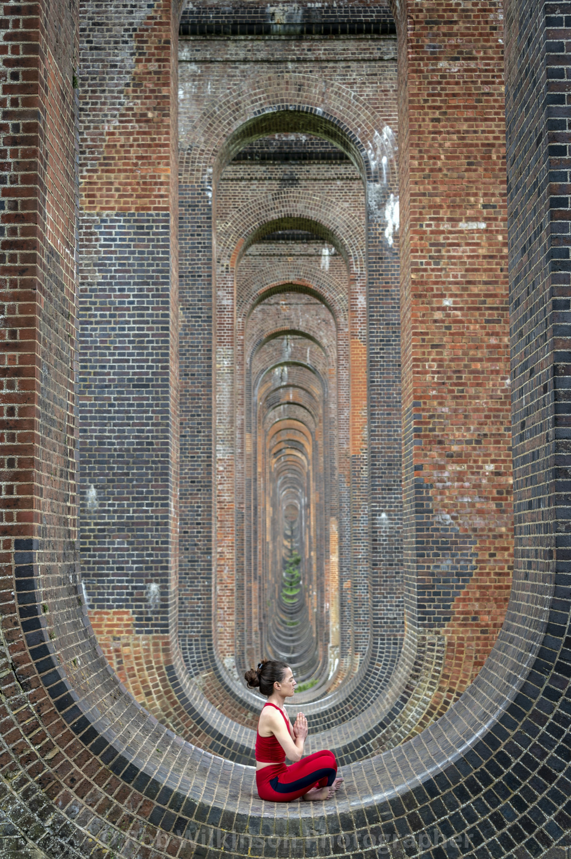 woman sitting in the arches of the Ouse Valley Viaduct