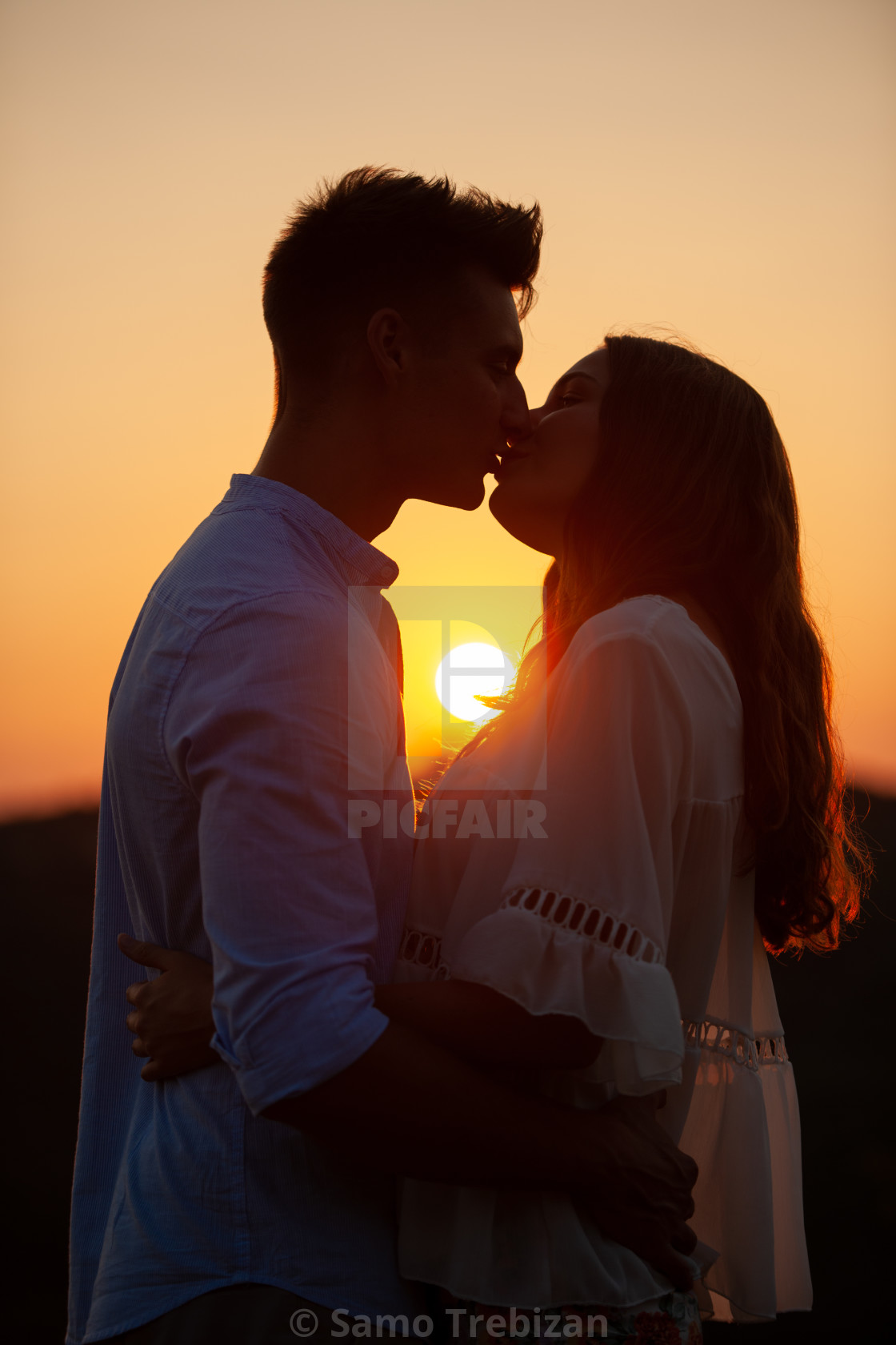 Silhouette of a beautiful romantic couple at sunset - License ...