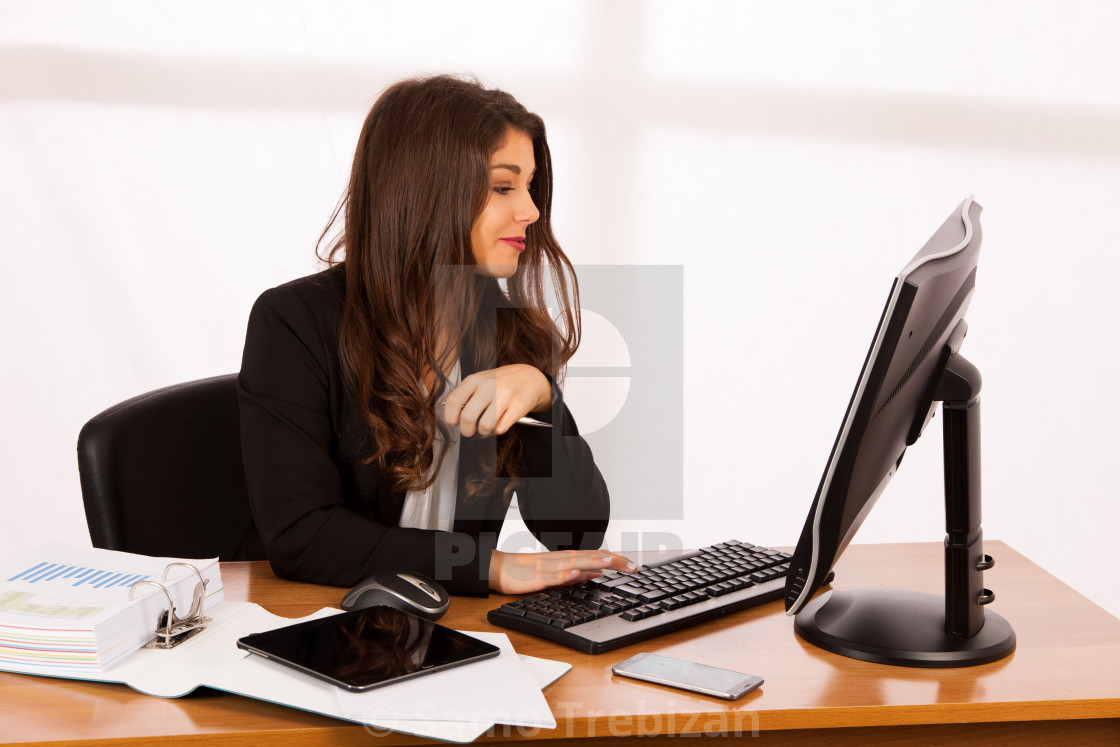 Beautiful young brunette business woman work in her office - License,  download or print for £ | Photos | Picfair