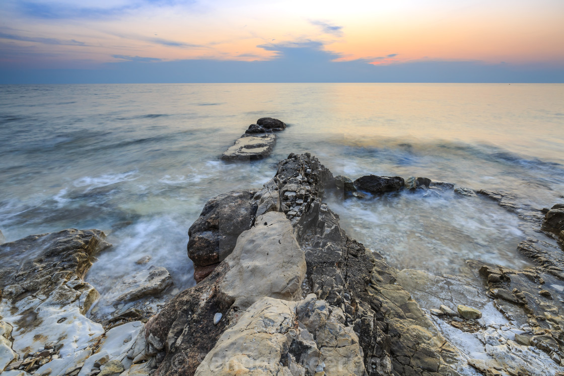 Enjoying The Colorful Sunset On A Beach With Rocks On The