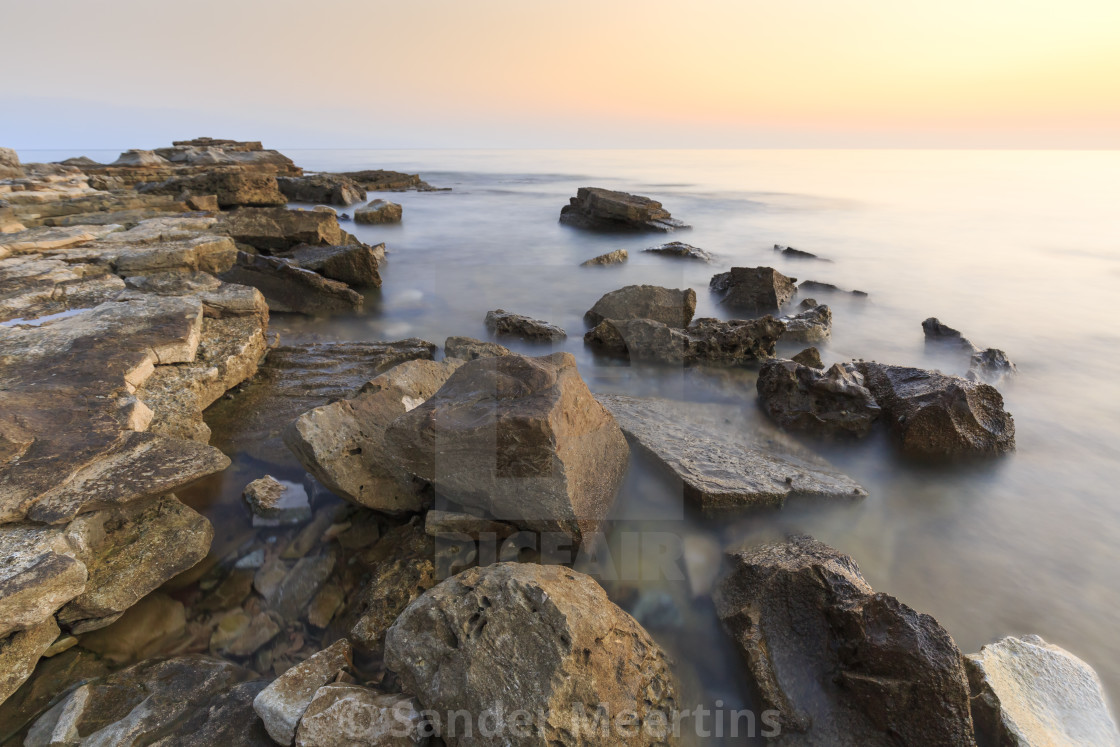 Enjoying The Colorful Sunset On A Beach With Rocks On The