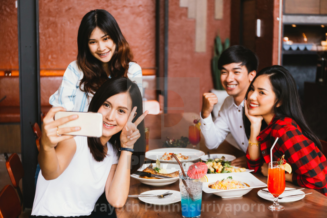 "Group of Happy Asian male and female friends taking a selfie photo an...