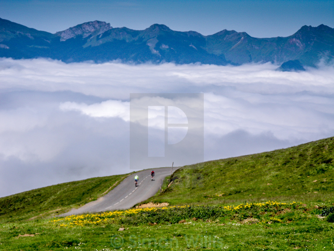 "Distant cyclists in pyrenees cloud" stock image