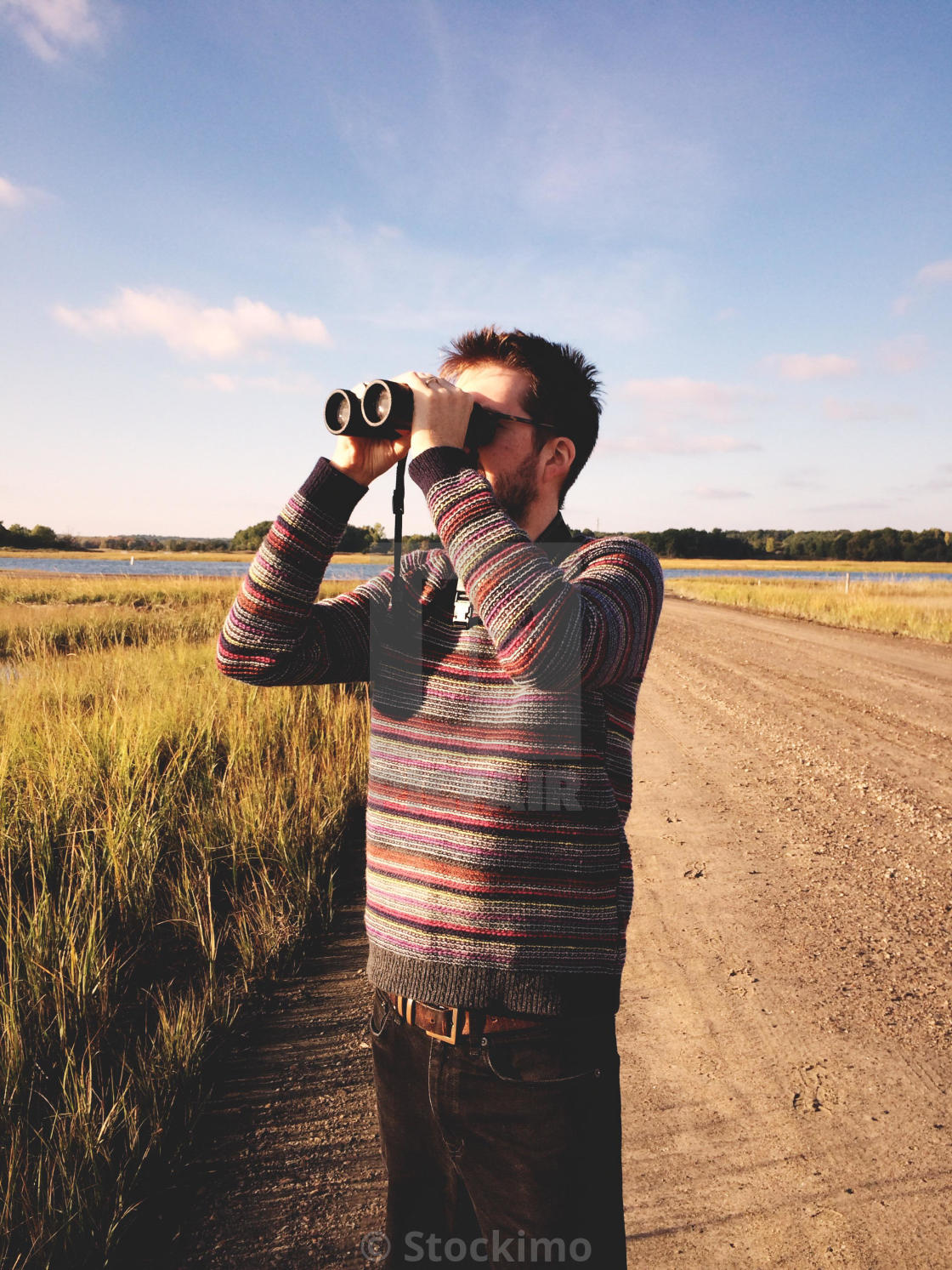 "A man birdwatching by a salt marsh in Connecticut, USA." stock image