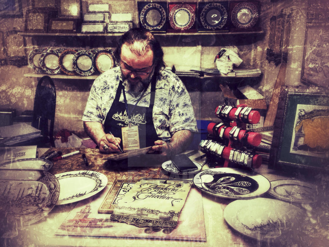 "Artisan making calligraphy on a dish during Ramadan events in Sultanahmet" stock image