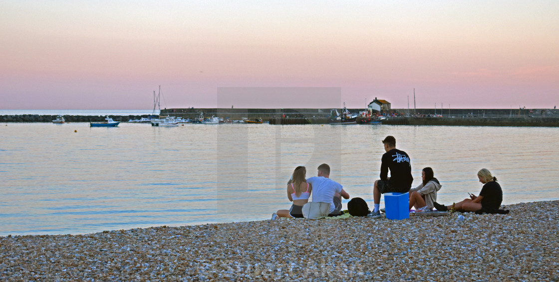 "Young Group on Lyme Regis Bay at Sunset" stock image