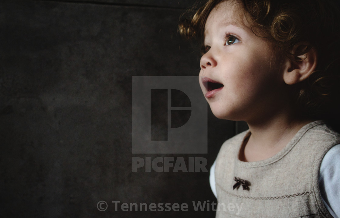 "Beautiful young girl looking away against a dark moody background" by Tennessee Witney - £4.91 "Beautiful young girl looking away against a dark moody background" stock image