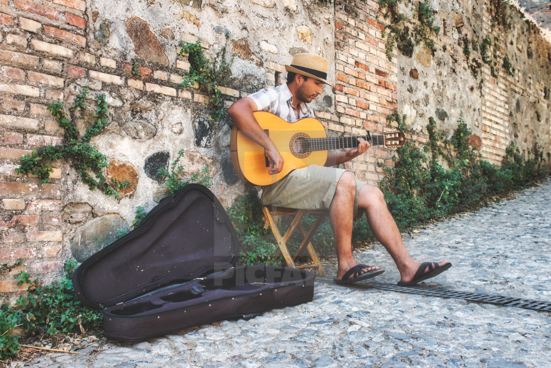 "Granada / Spain - August 21 2019: A male busker sitting playing the Spanish..." by Tennessee Witney - £4.91 "Granada / Spain - August 21 2019: A male busker sitting playing the Spanish..." stock image