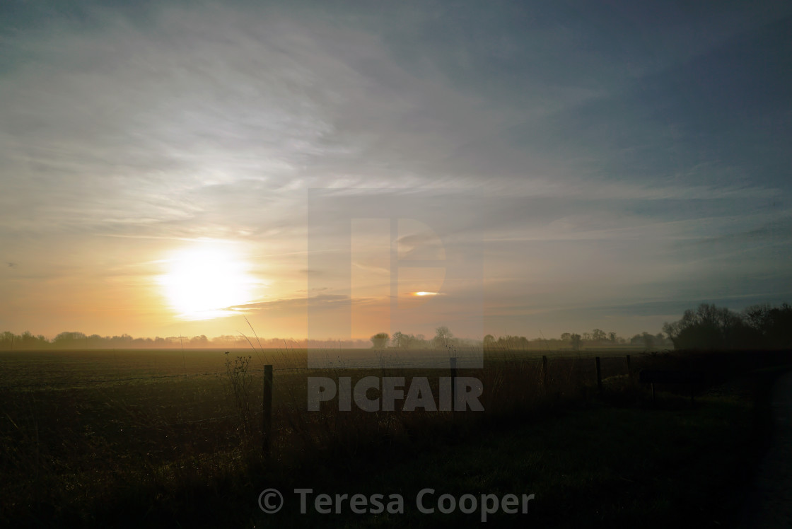 "Sunrise over the fields and a rare rainbow cloud" stock image